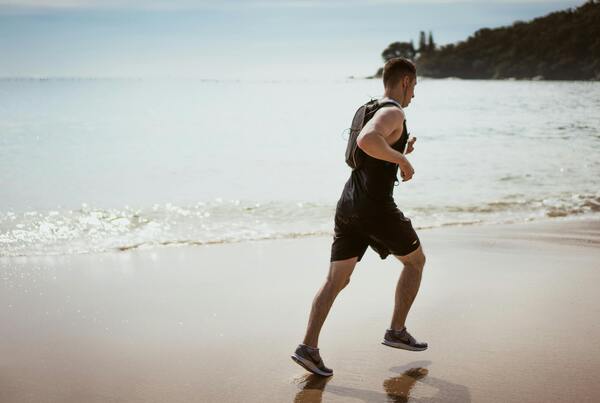 homem correndo na praia