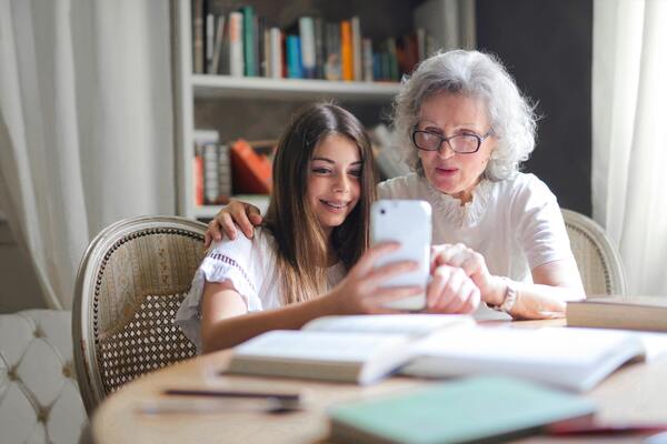 uma senhora e uma crianaça conversando e mexendo no celular